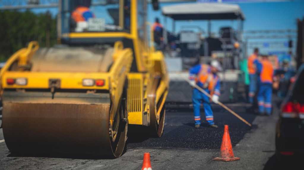 Construction work of asphalt sheets, asphalt sheets and dampers in the building and in the repairs of street craftsmen, who work on the new street construction works and in a dream on a Schicht image